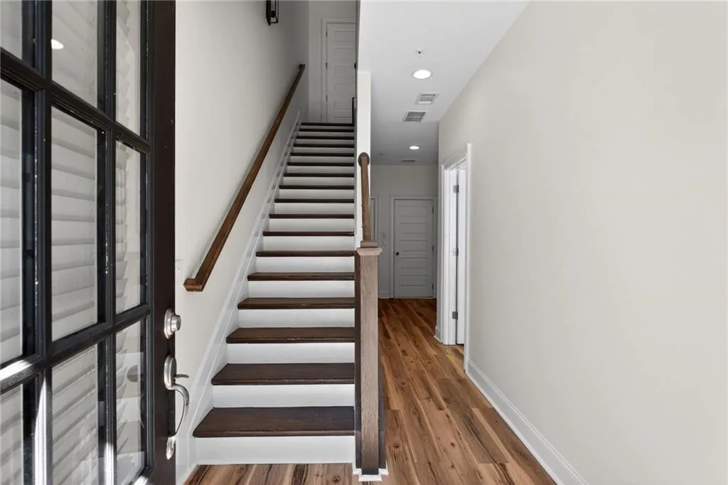 Stairway with recessed lighting and wood finished floors
