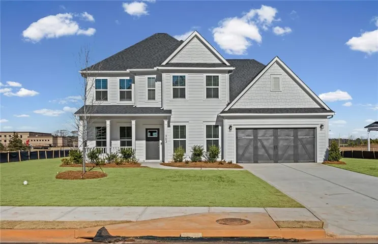 Modern two-story residence with a gray exterior, dark shingle roof, and gabled accents
