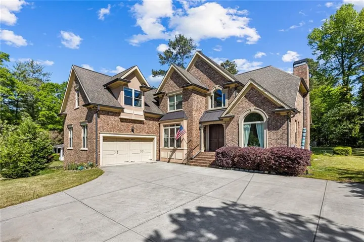 Brick exterior with multiple gables and a stone chimney