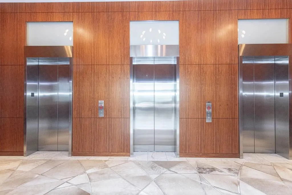 Kitchen with modern cabinets, elevator, and brown cabinetry