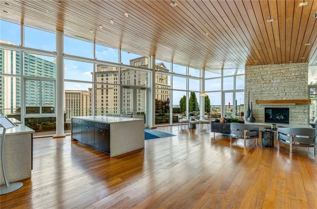 Building lobby featuring a wall of windows, wood ceiling, a city view, and a high ceiling