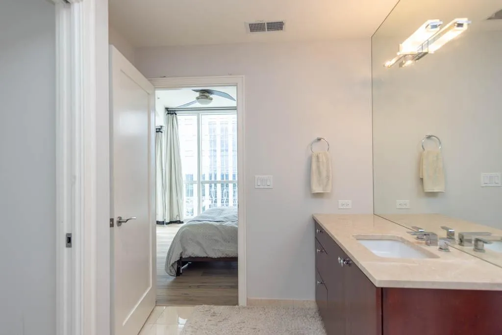 Ensuite bathroom featuring vanity and light tile patterned floors