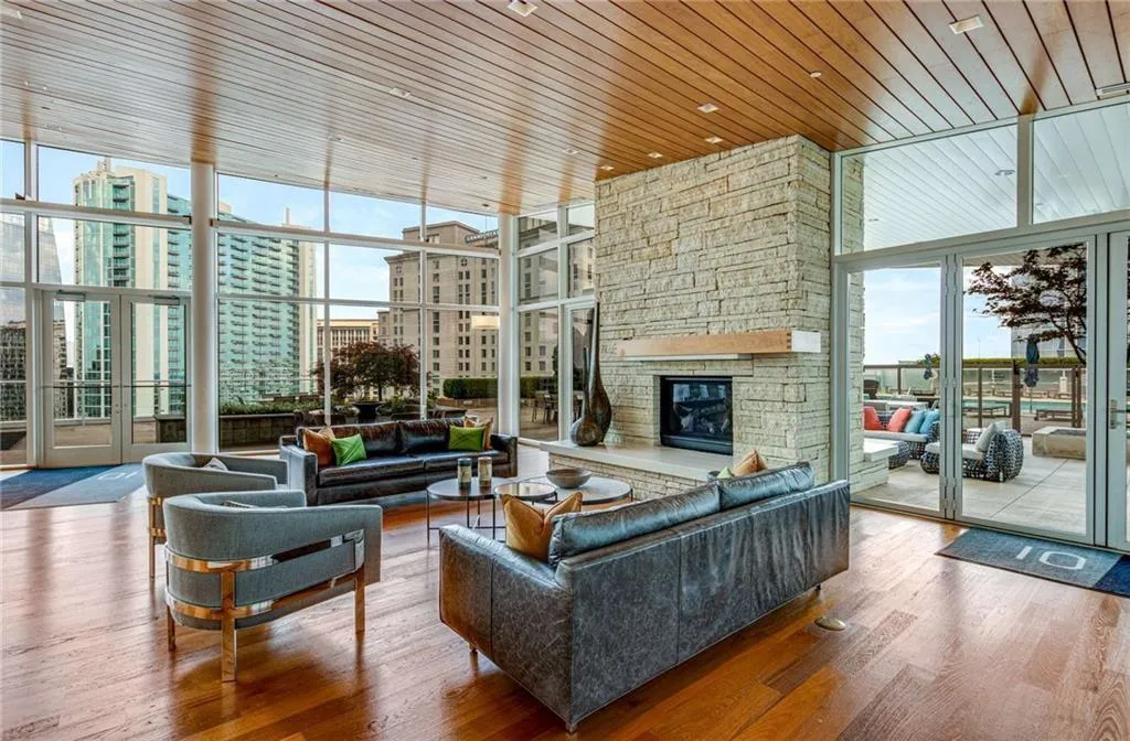 Living room with a wall of windows, wooden ceiling, wood finished floors, a fireplace, and a view of city