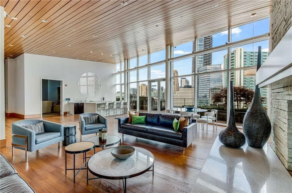Community lobby featuring a view of city, expansive windows, wooden ceiling, and a high ceiling