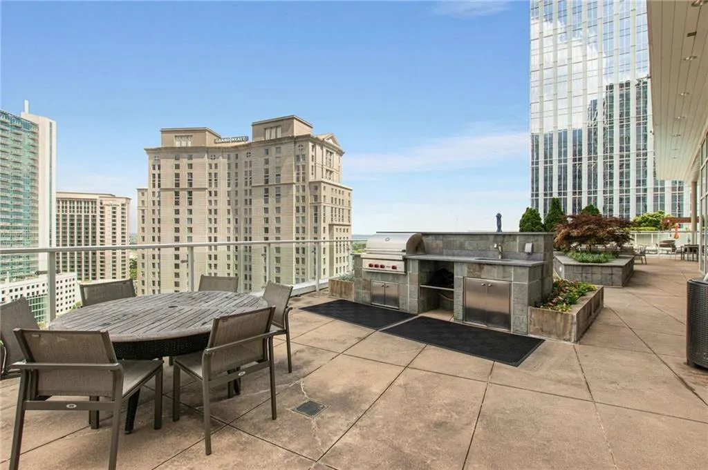 View of patio with outdoor dining area, area for grilling, and a city view