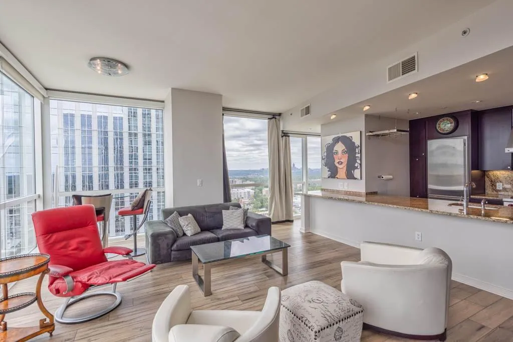 Living room with floor to ceiling windows and light wood-style flooring