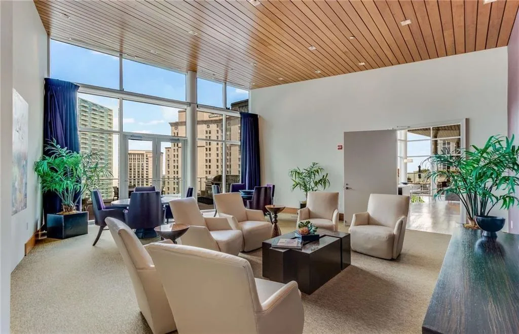 Community lobby featuring expansive windows, wood ceiling, and a city view