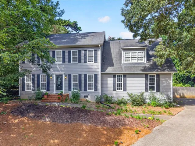 Traditional two-story residence featuring grey siding and dark shutters