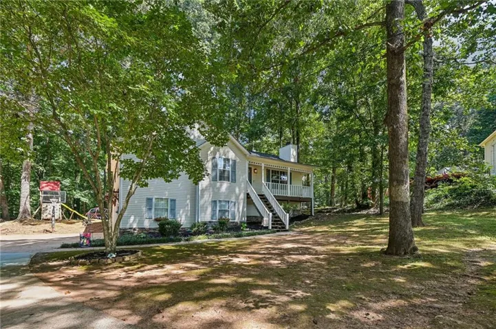 Vinyl siding with a covered porch, white siding, and light blue shutters