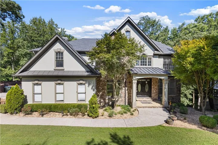 Stucco and stone exterior with multiple gables and a covered entry