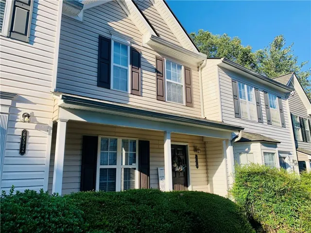 Two-story siding exterior with contrasting shutters and a covered porch entry