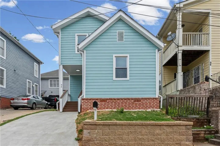Light blue siding exterior with white trim accents and a brick foundation
