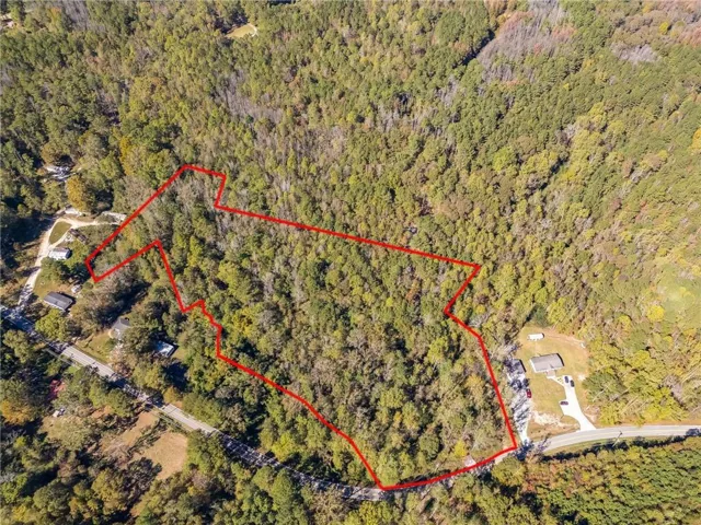 Aerial overview of property's location with property parcel outlined and a forest