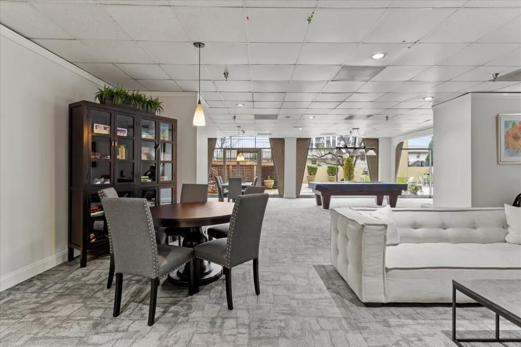 Dining room with billiards, a paneled ceiling, recessed lighting, and light colored carpet