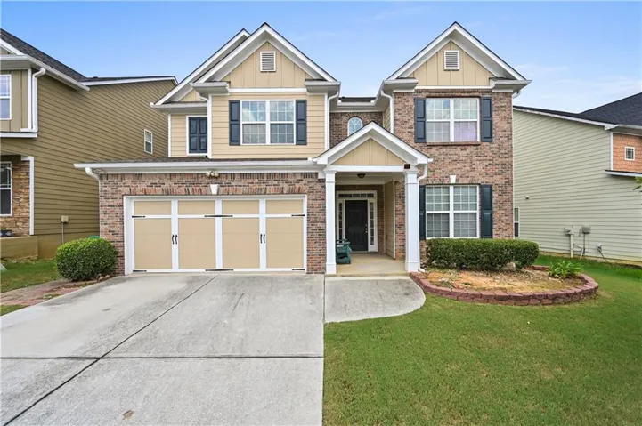 Brick and siding exterior, two-car garage, covered entry, and front landscaping