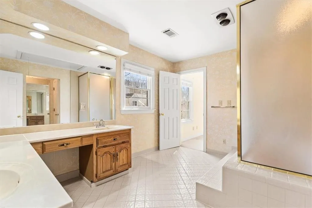 Full bathroom with vanity, wallpapered walls, recessed lighting, and a bath