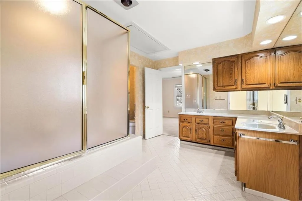 Kitchen featuring light countertops, wood finish cabinets, a peninsula, recessed lighting, and light tile patterned floors