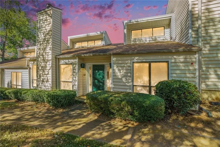 Exterior featuring horizontal siding, multiple dormer windows, a prominent chimney, and a vibrant green front door