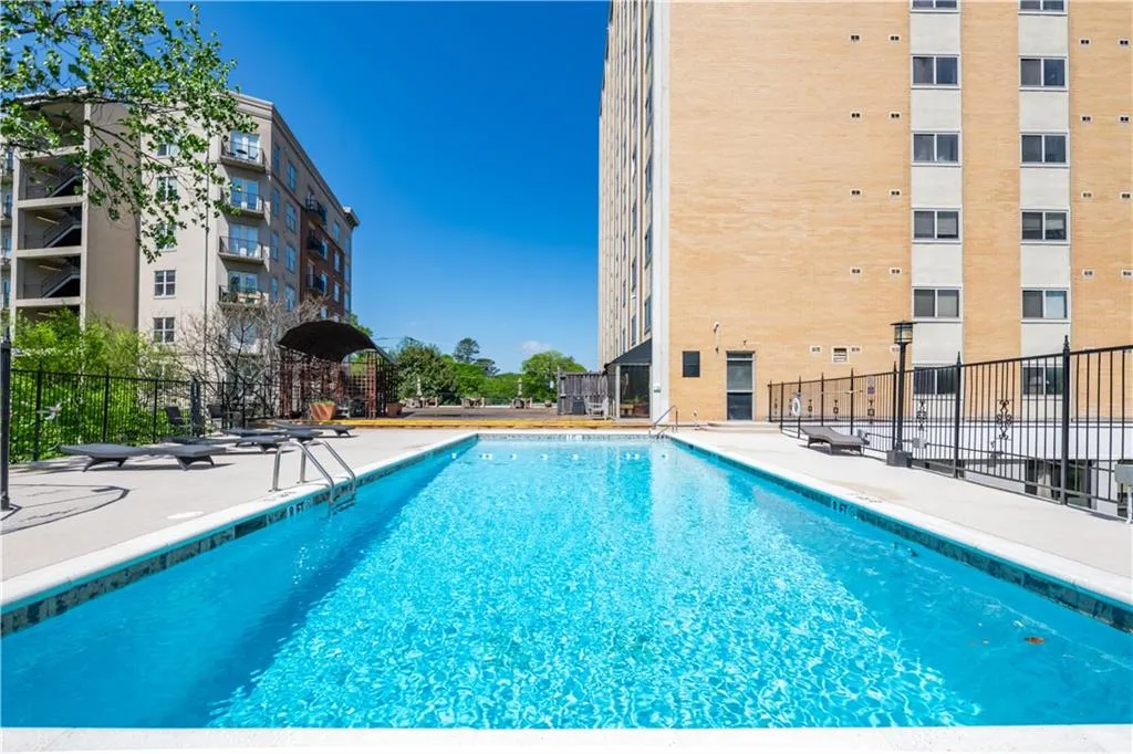 Community pool featuring fence and a patio area