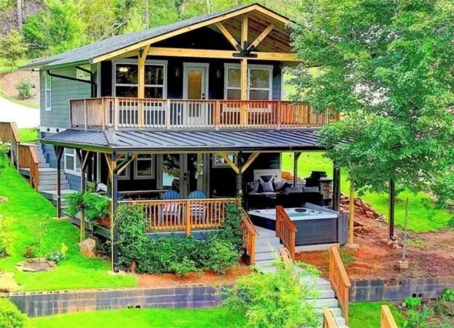 Multi-level exterior with a covered lower patio and an upper-level balcony, both featuring wood railings