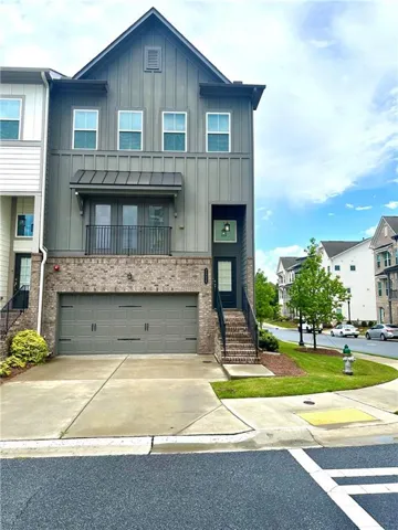 Modern two-story residence featuring a striking board-and-batten exterior in charcoal gray with coordinating stone veneer base