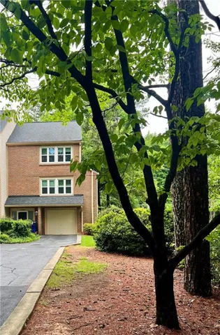 Brick exterior featuring multiple windows and a single-car garage