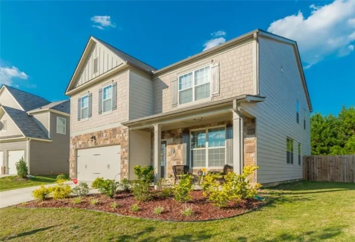 Two-story exterior with a covered porch, stone facade accents, and a two-car garage