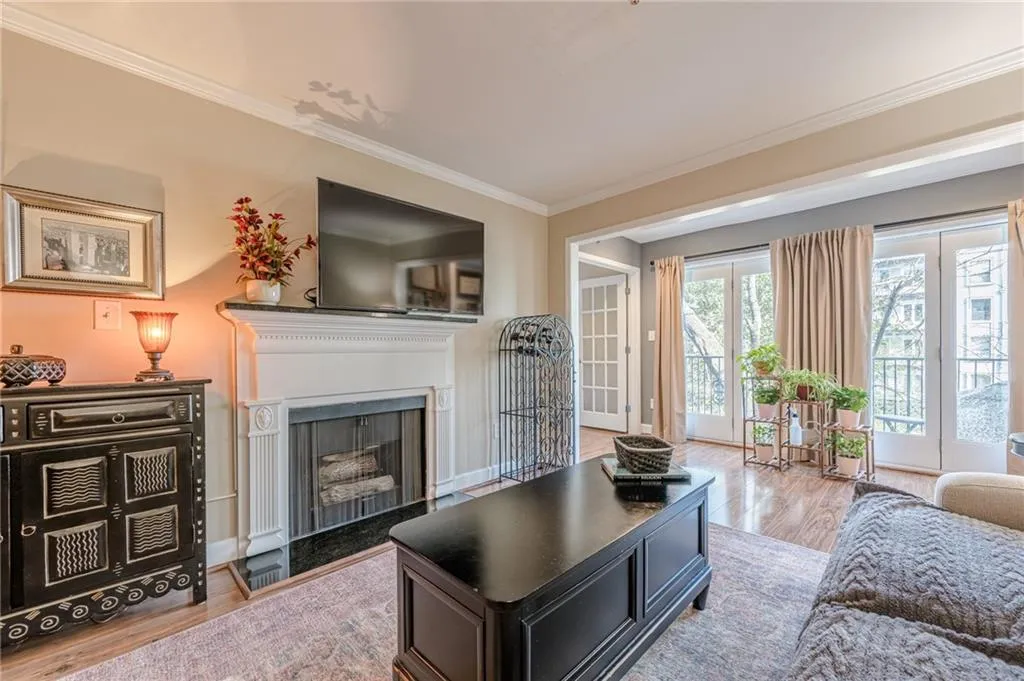 Living area featuring ornamental molding, wood finished floors, and a fireplace