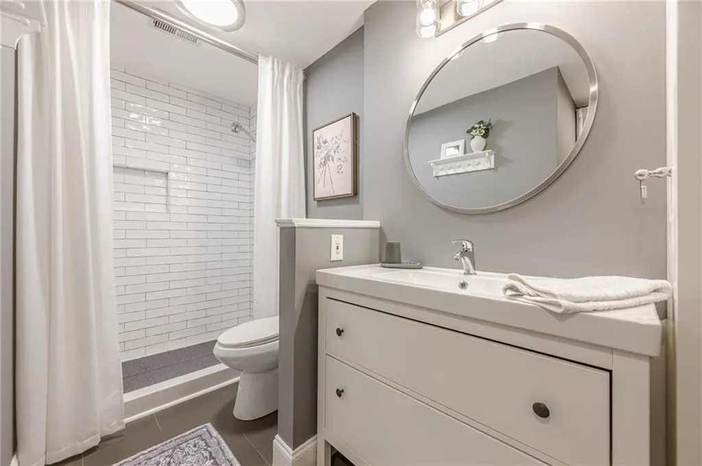 Bathroom featuring tile patterned floors, vanity, and tiled shower