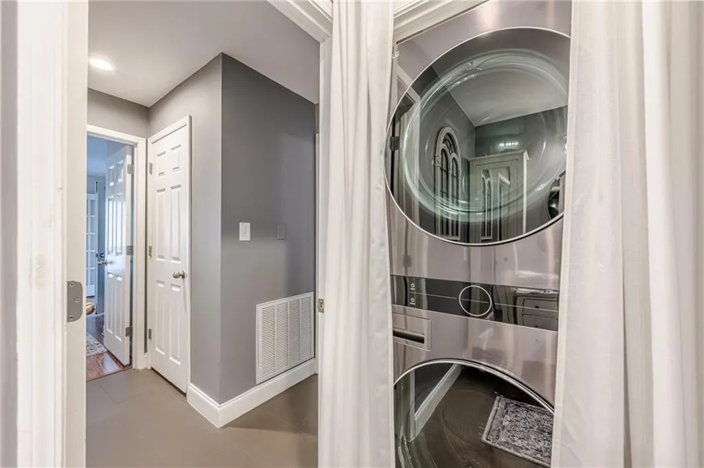 Laundry room with stacked washer and clothes dryer and baseboards