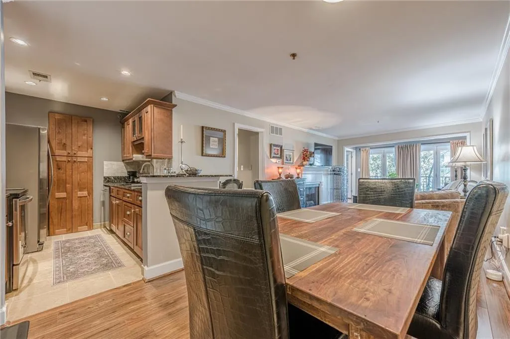 Dining space with ornamental molding, light wood finished floors, and recessed lighting