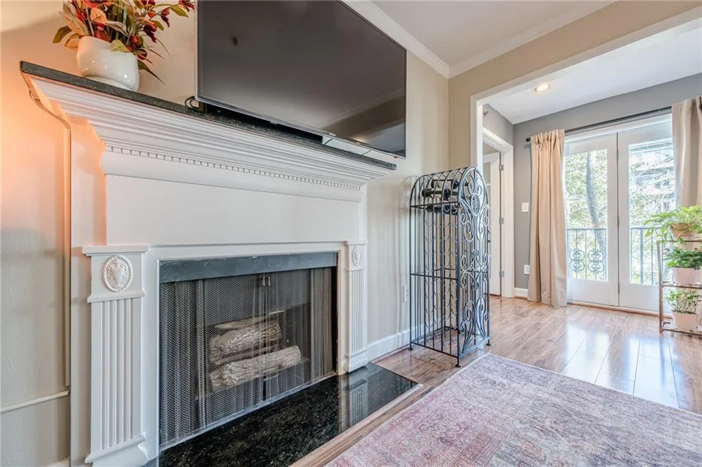 Detailed view of ornamental molding, a fireplace with flush hearth, and wood finished floors