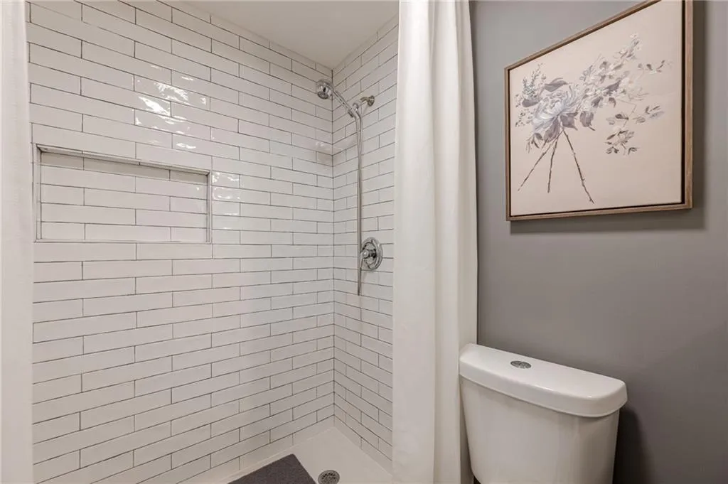Full bath with a shower stall and toilet