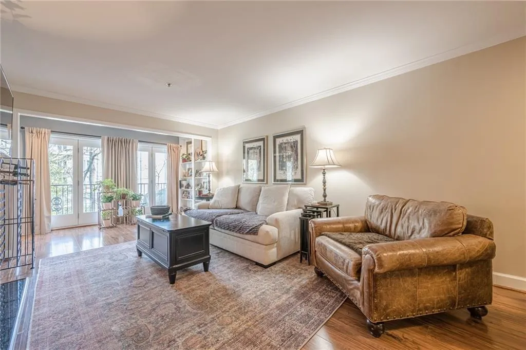 Living area with ornamental molding and wood finished floors