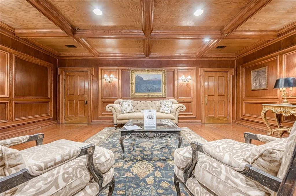 Living area with a wooden ceiling with exposed beams, recessed lighting, light wood-style flooring, and wooden walls