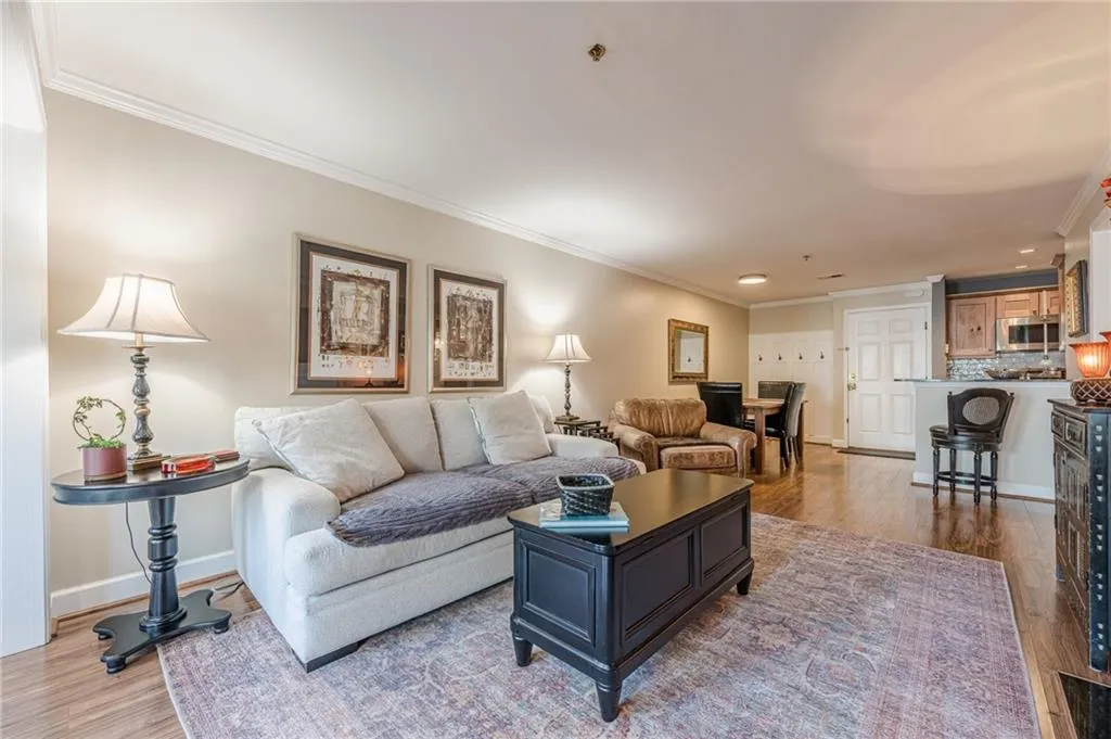 Living area featuring wood finished floors, crown molding, and recessed lighting