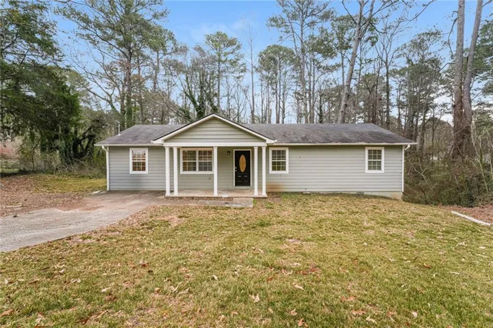 Ranch-style home with a porch, a front yard, and a shingled roof