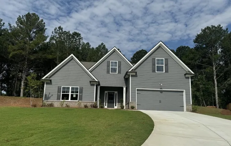 Craftsman inspired home with concrete driveway, a front lawn, an attached garage, and stone siding