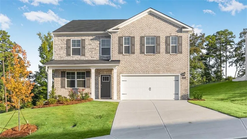 Two-story residence featuring a brick and stone facade, a covered front entry, and a two-car garage