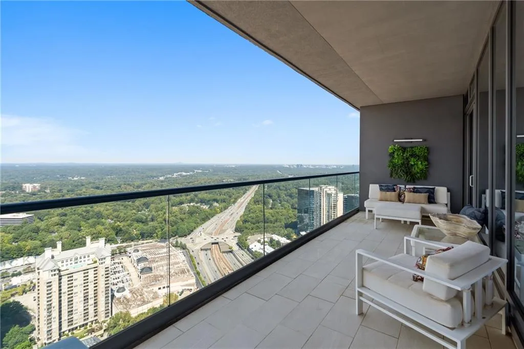 Balcony featuring a view of city and a sunroom