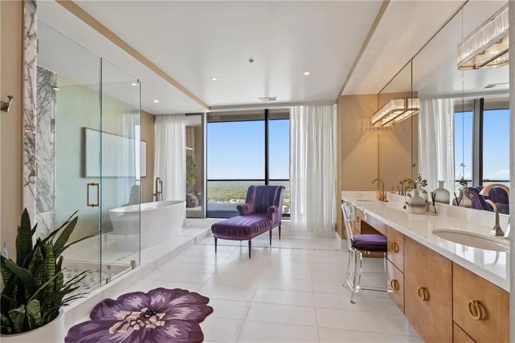 Full bathroom featuring double vanity, a freestanding bath, a shower stall, light tile patterned floors, and expansive windows