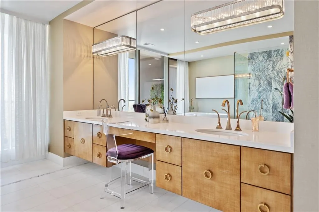 Full bath featuring double vanity, light tile patterned floors, and healthy amount of natural light