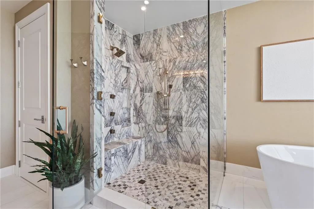 Full bath featuring a soaking tub and a marble finish shower