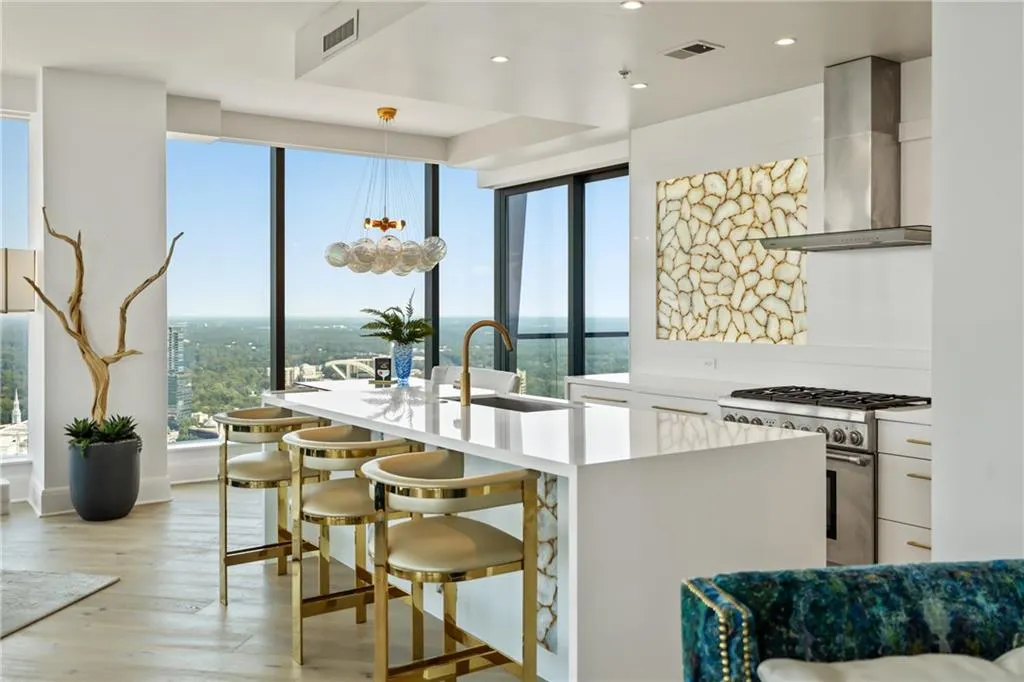 Kitchen featuring hanging light fixtures, plenty of natural light, high end range, wall chimney exhaust hood, and recessed lighting