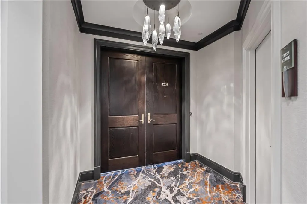 Foyer entrance featuring crown molding and a chandelier