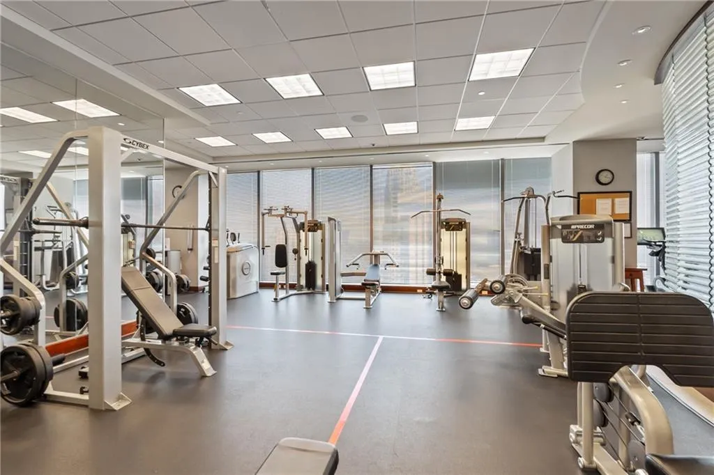 Exercise room with floor to ceiling windows and a drop ceiling