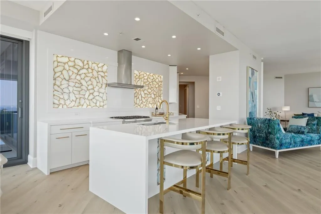 Kitchen featuring white cabinetry, light wood finished floors, light stone countertops, recessed lighting, and modern cabinets