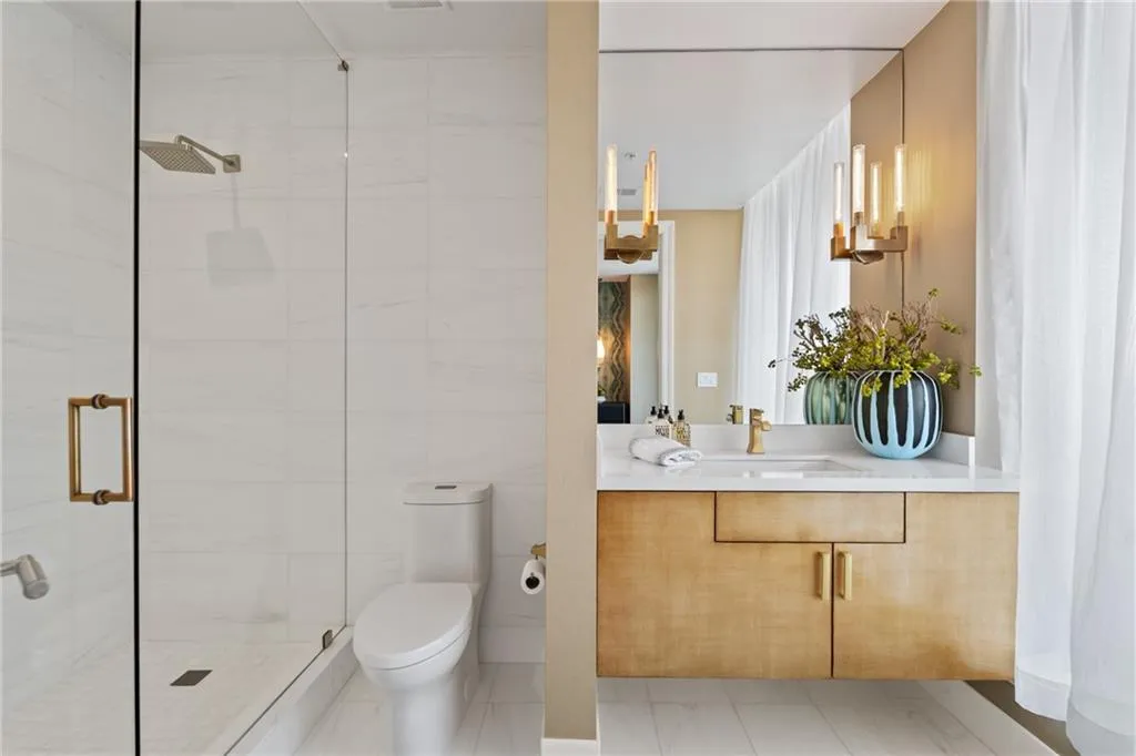 Bathroom featuring vanity, a stall shower, and tile walls