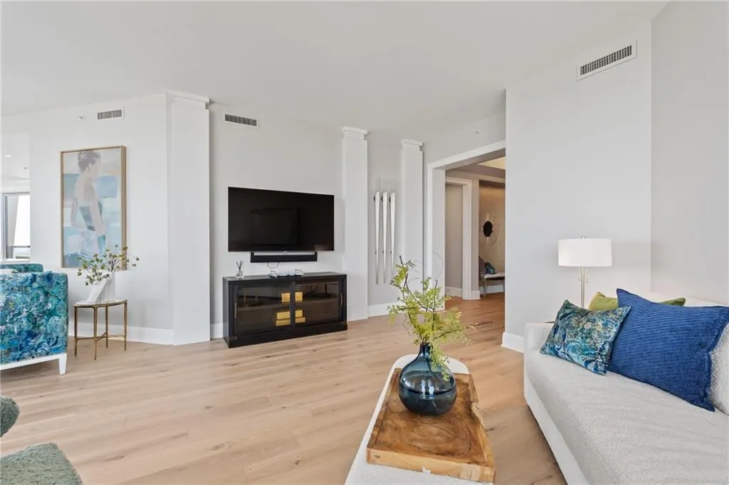 Living area featuring light wood finished floors and decorative columns