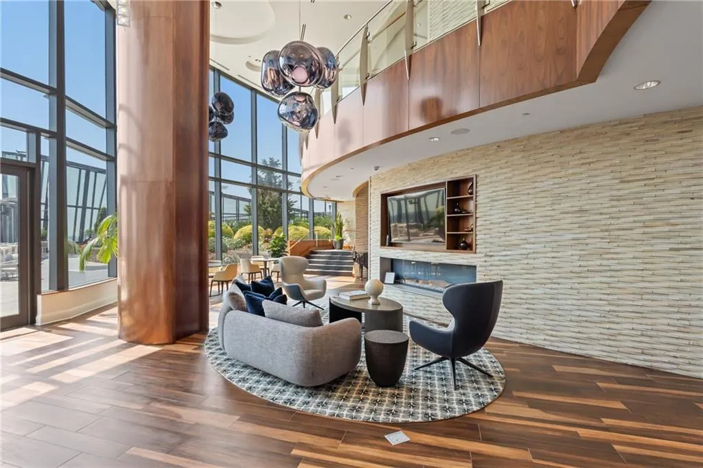 Building lobby with a towering ceiling, a wall of windows, and recessed lighting